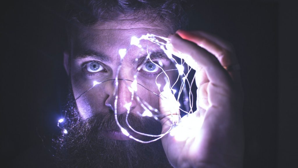 Man with beard holding a wire with lights