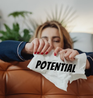 Woman tearing up a piece of paper with the word potential